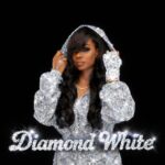 Diamond White wearing a sparkling silver hooded outfit